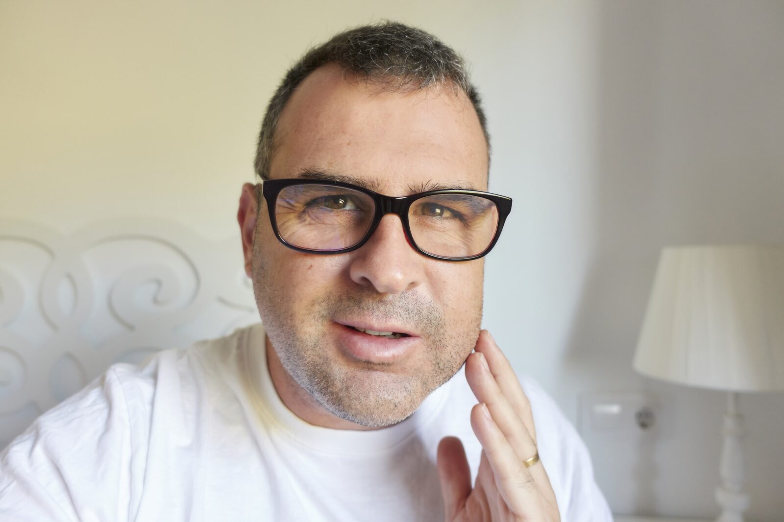 a man with phlegmon from a tooth root infection who touches his face because of pain
